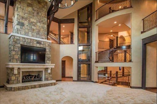 Glass elevator in large main living area of luxury home